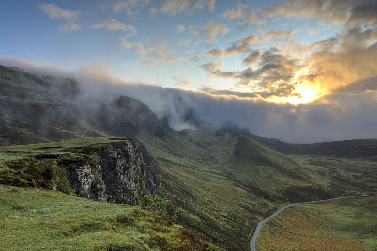 Paisaje de cielo abierto con capas de nubes y montañas al fondo