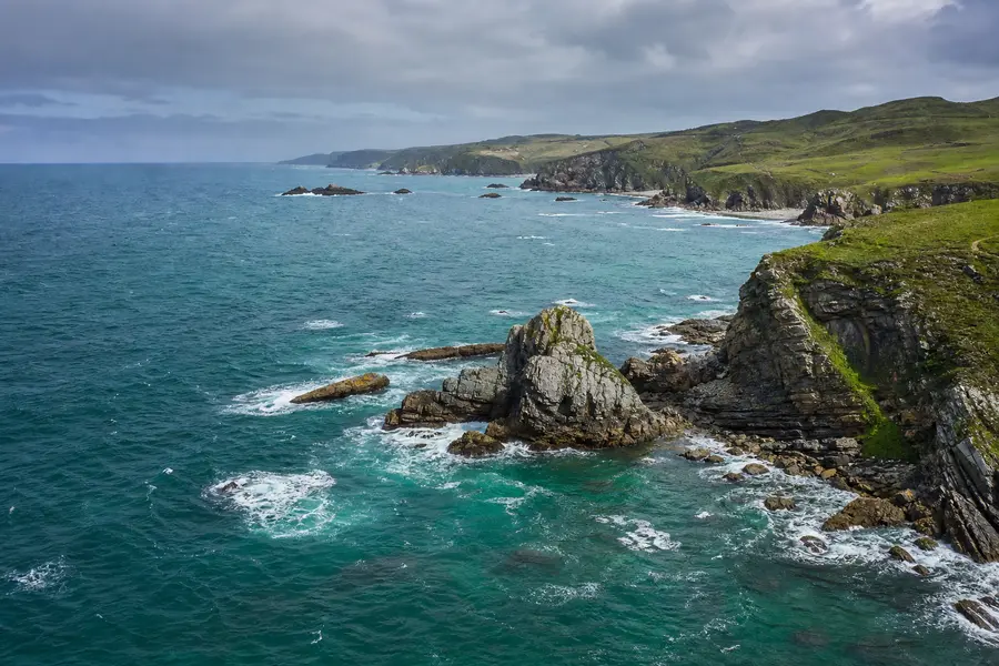 Costa abrupta del norte de España con acantilados y mar verde